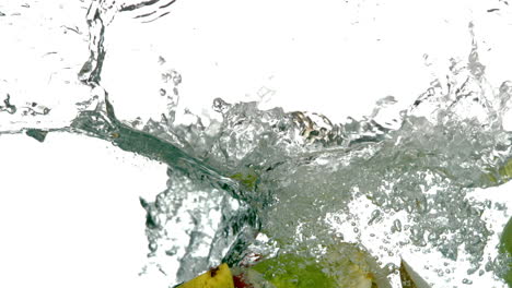 pear and apple segments plunging into water on white background