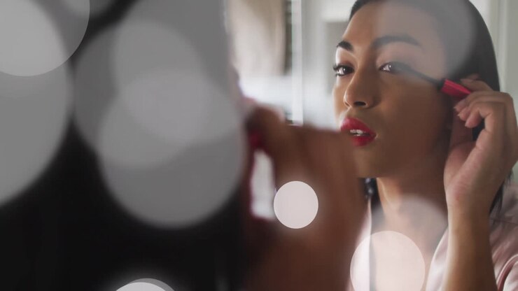Animation of light spots over biracial woman applying mascara