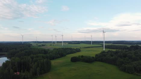 Green-landscape-and-wind-turbine-farm,-aerial-ascend-view