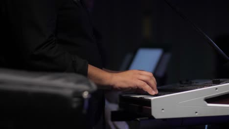 musician-playing-synthesizer-with-his-fingers-side-view-slow-motion-close-up