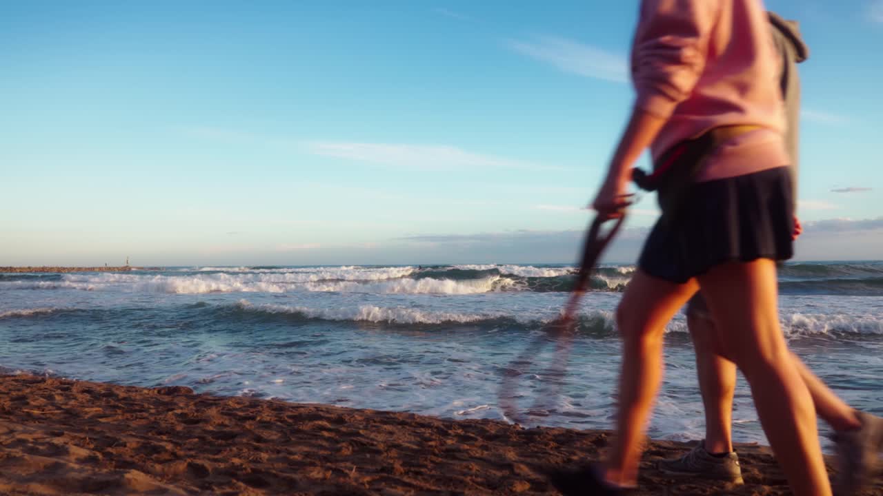 거리에 서퍼와 지나가는 사람들과 일몰 동안 파도