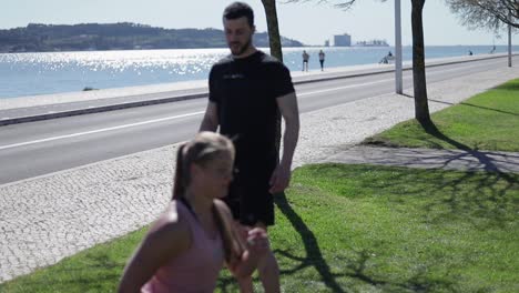 sporty young woman doing sit ups with trainer in park.