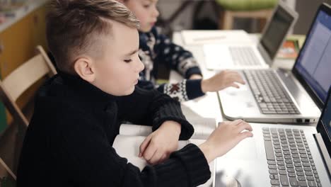 Zwei-Kleine-Jungen-Sitzen-Vor-Ihren-Laptops-Und-Lernen-Das-Programmieren.