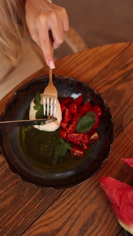 woman eating caprese salad