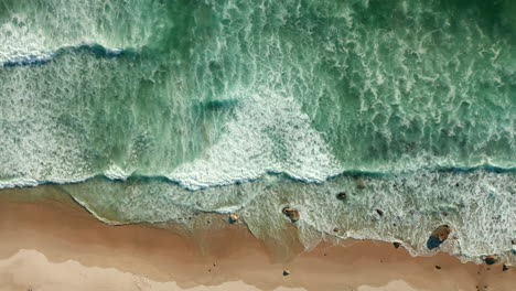 Olas-De-Mar-Espumosas-Salpicando-En-La-Orilla-Arenosa-En-La-Playa-De-La-Bahía-De-Kogel,-Ciudad-Del-Cabo,-Sudáfrica---Vista-Aérea-De-Arriba-Hacia-Abajo