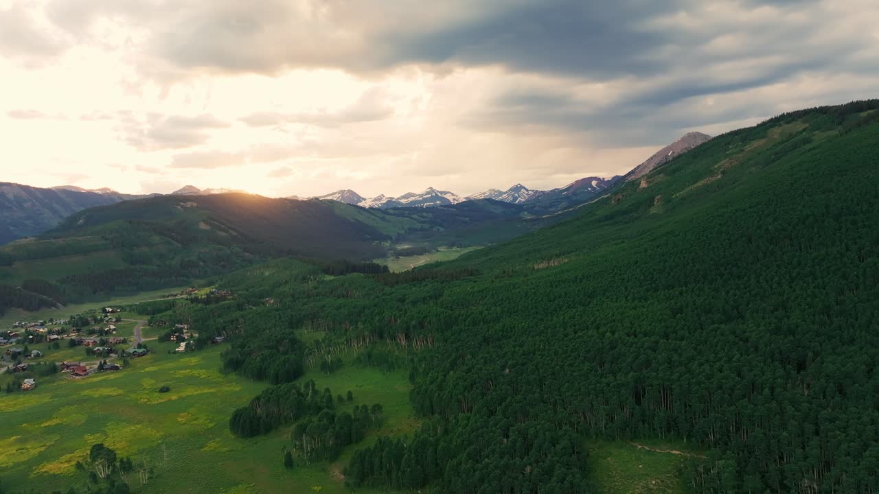 Aerial at sunset over a lush green valley near Crested Butte mountain, Colorado, USA