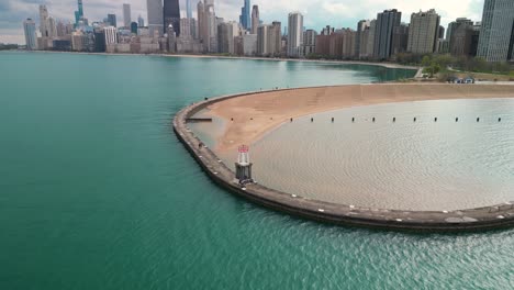 Aerial-descent-of-North-Avenue-Beach-Pier-and-Chicago-skyline