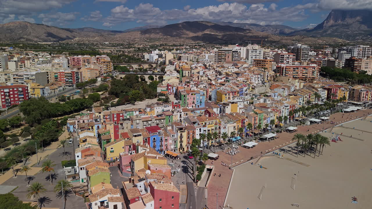 Vista aérea da colorida cidade costeira de Villajoyosa com casas históricas, calçadão da praia e costa mediterrânea na Espanha. Imagens 4k de alta qualidade.