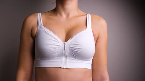 Woman-Standing-With-White-Surgical-Bra-Post-Breast-Augmentation-Surgery