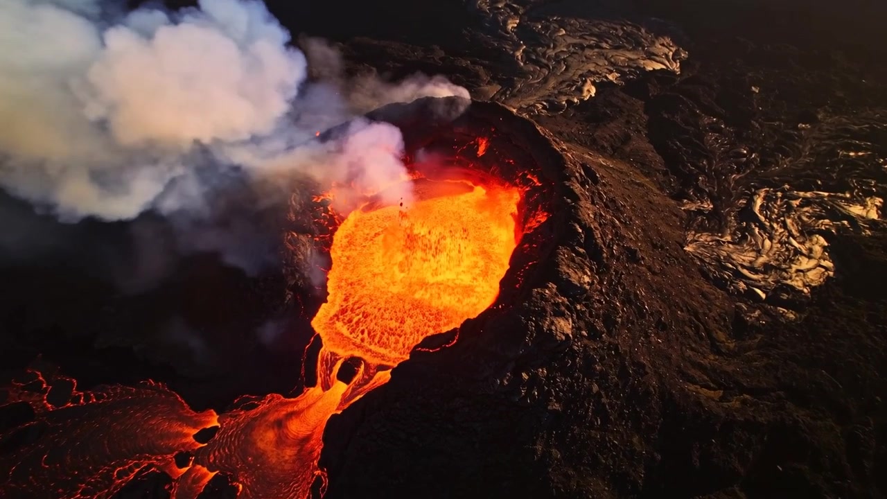 Lago di lava ribollente che alimenta canali di trabocco presso una bocca vulcanica, con gas che spinge il pennacchio e gli schizzi.