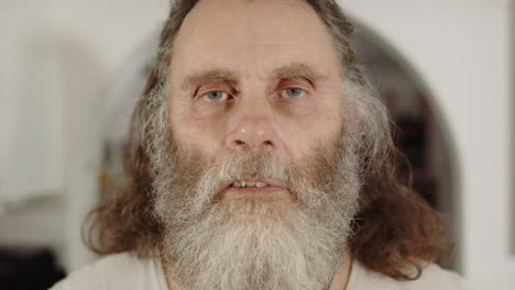 ungroomed bearded man with neutral facial expression, frontal portrait
