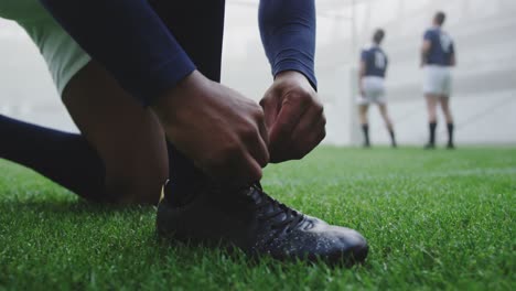 rugby player tying shoelaces in the stadium 4k