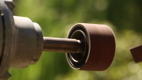 detail of a man´s hand using a bench grinder on a sunny day