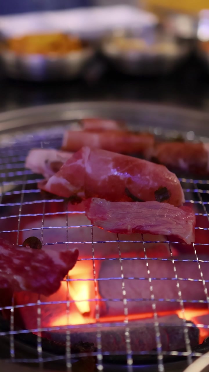 Daging sapi dan bacon sedang dipanggang di atas panggangan restoran