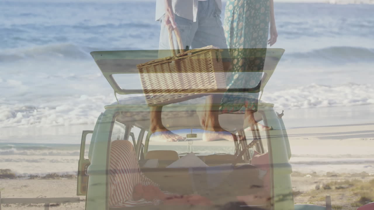 Carrying picnic basket, couple unloading car trunk at beach with animation