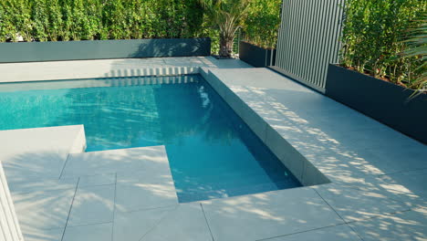 a modern italian-style minimalist pool, with light gray tiles and crystal clear water creates a relaxing atmosphere