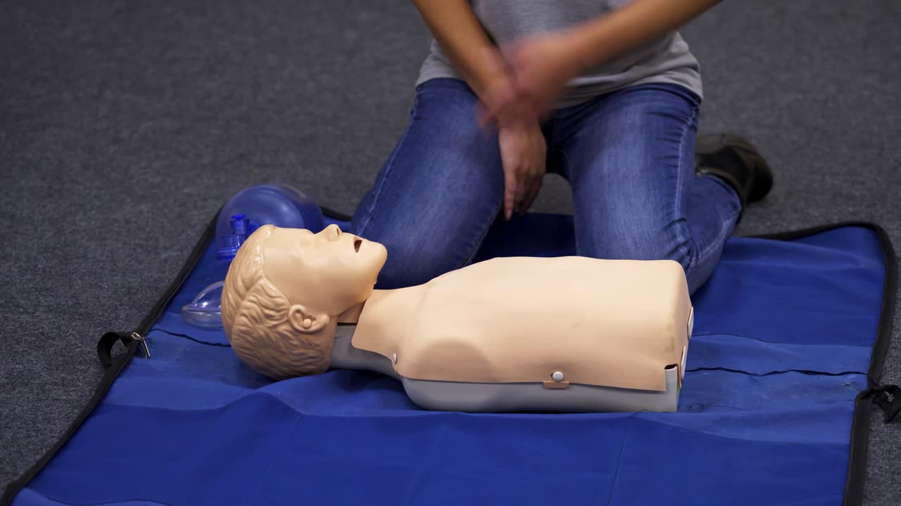 CPR training medical procedure. Demonstrating chest compressions on CPR doll in the class. Video from medical courses