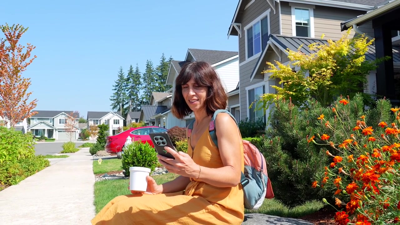 Woman Sitting Outside Her Home Using a Smartphone
