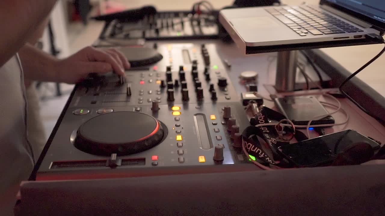 primer plano de un dj tocando música en un evento en interiores.