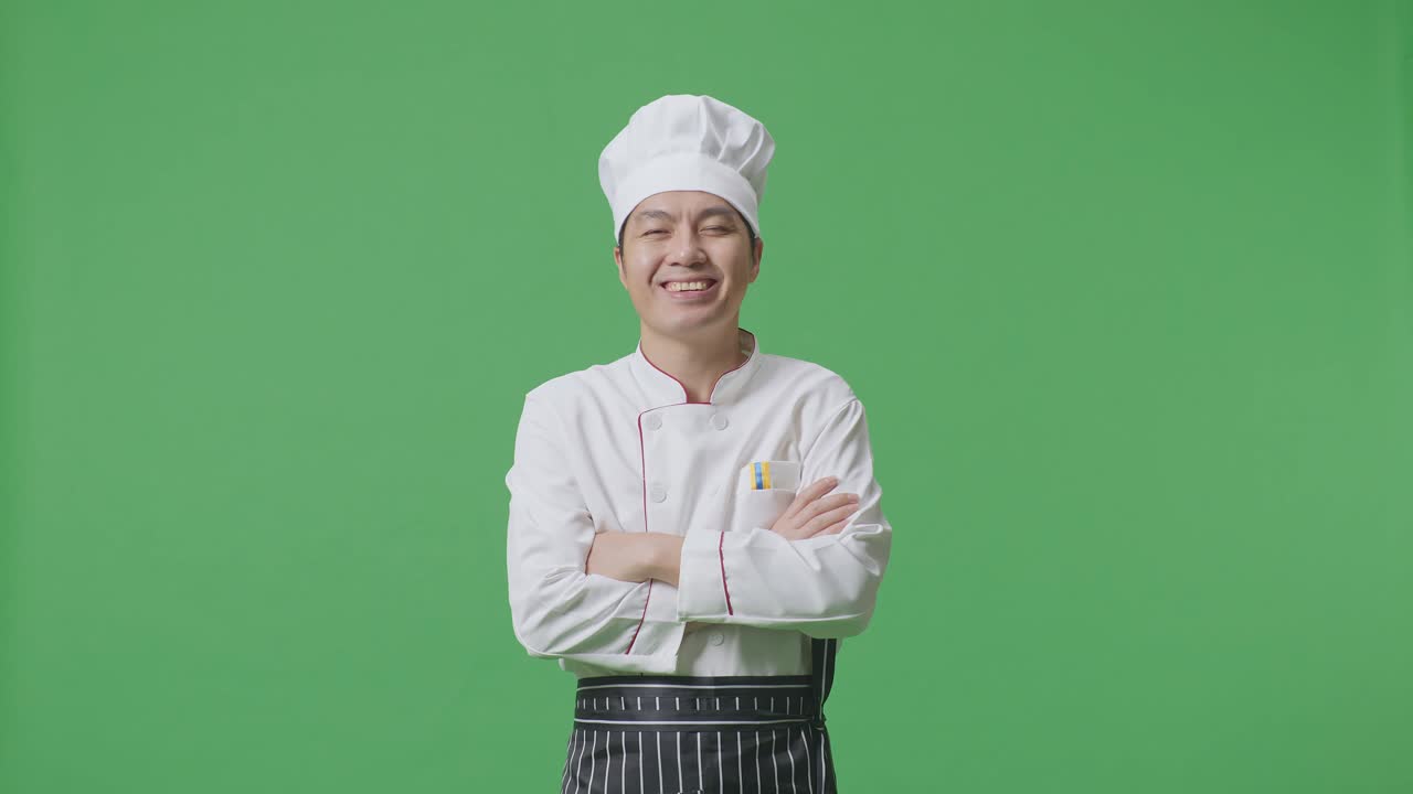 Asian Man Chef Smiling And Crossing His Arms To Camera While Standing In The Green Screen Background Studio