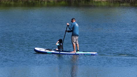 adulto y niño disfrutando juntos de paddleboard