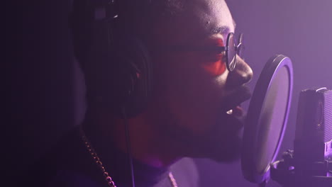 man singing into microphone in recording studio