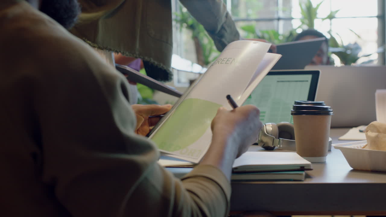 아프리카계 미국인 사업가들이 팀장을 만나고 회사 문서를 공유하는 여성 동료들이 창의적인 프로젝트에서 함께 일하고 트렌디한 지속가능한 사무실에서 아이디어를 모으고 있습니다.