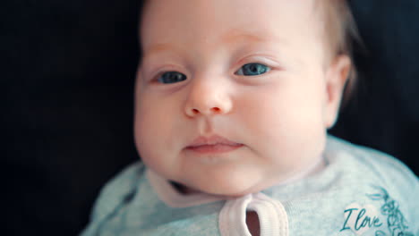 newborn baby with blue eyes on a black background