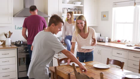 familia con hijos adolescentes preparando el desayuno en la cocina