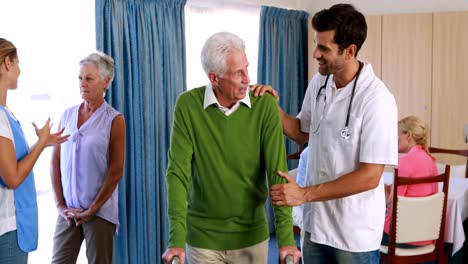 Arzt-Hilft-Seniorman-Beim-Gehen-Mit-Gehhilfe