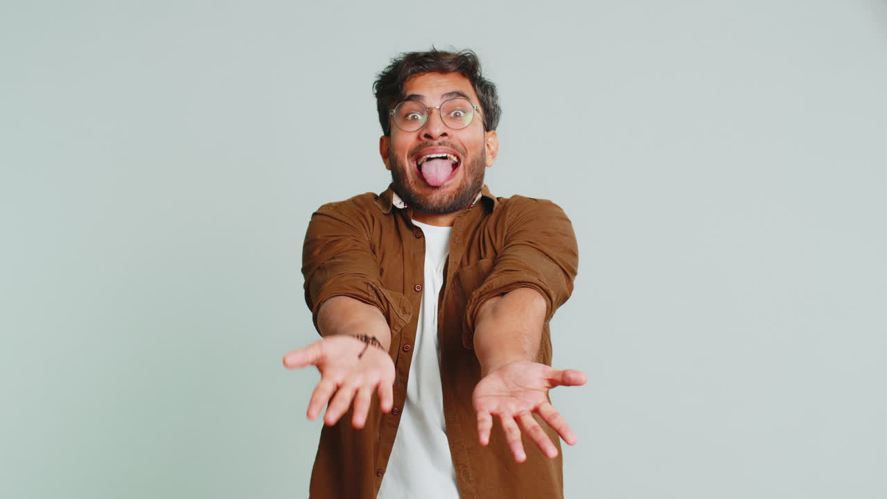 un hombre indio cómico haciendo expresiones faciales tontas, haciendo muecas, haciendo tonterías, mostrando la lengua