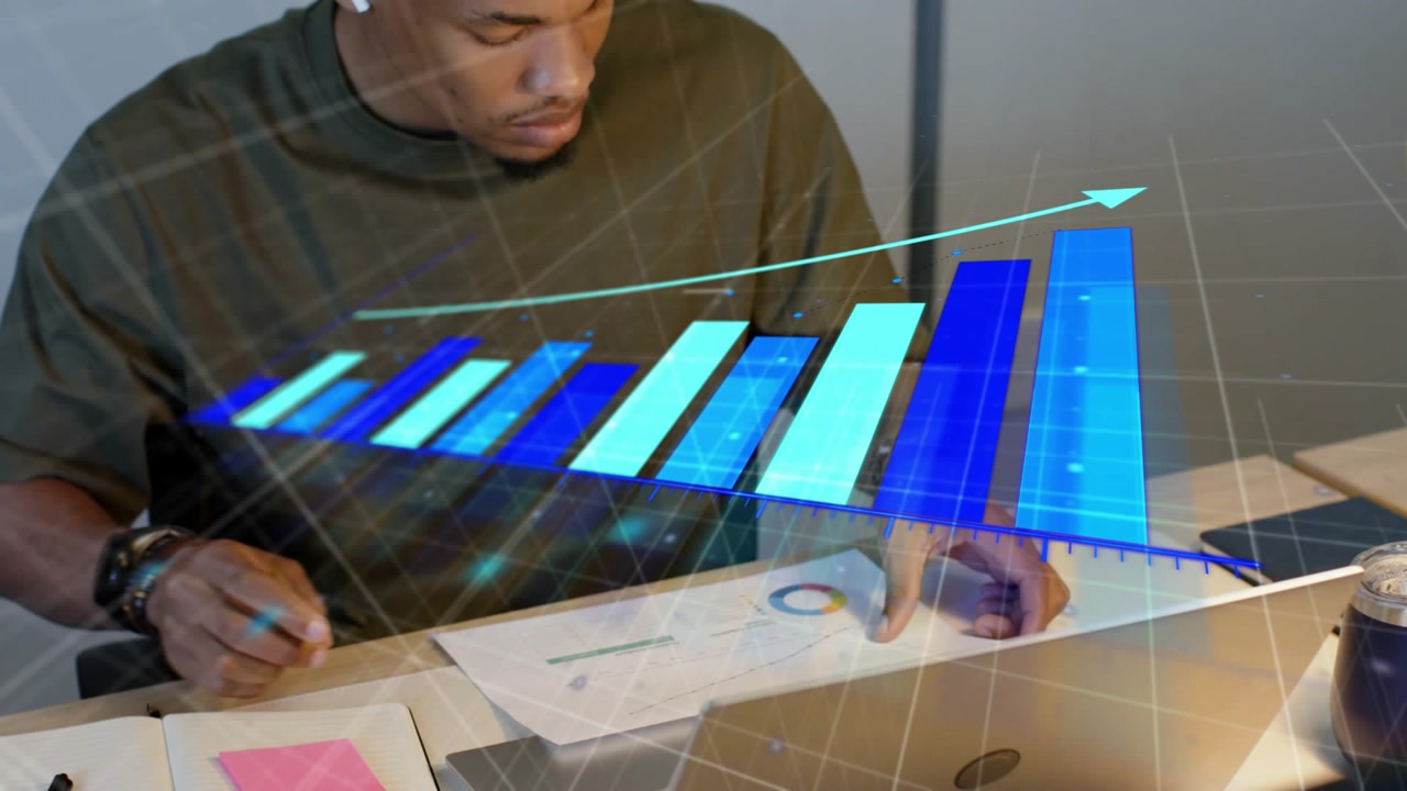 Man writing, switching laptop, reviewing reports under hovering 3D chart growing right for business