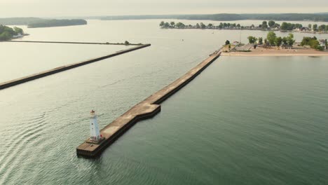 disparo de un dron retrocediendo desde la pequeña casa de luz en sodus point, lugar de vacaciones de nueva york en la punta de la tierra a orillas del lago ontario.