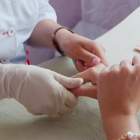 woman gives a manicure in a salon