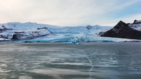 vista panorámica aérea de un glaciar con formaciones de hielo con textura, en islandia, al atardecer