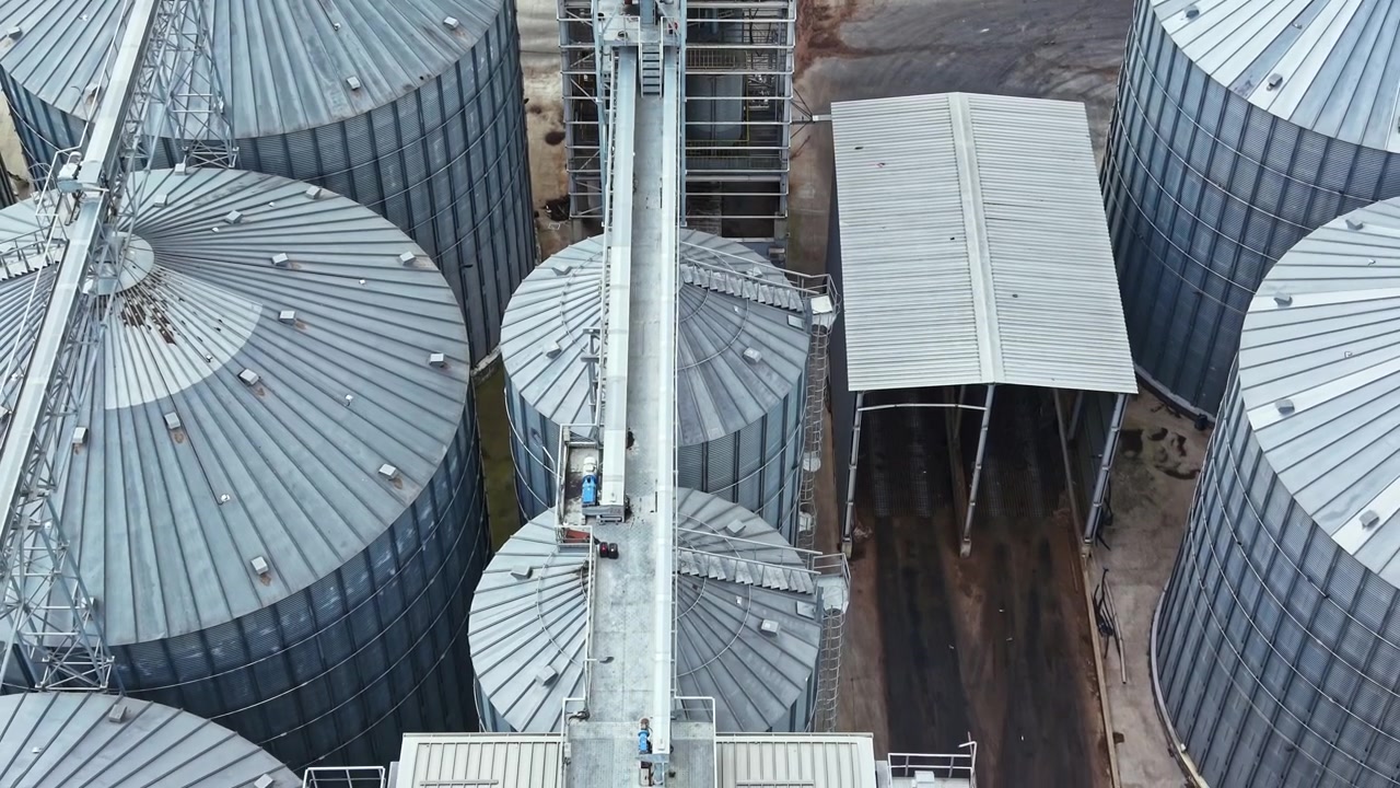 Storage silos on a farm with grain transport systems in rural area during daylight