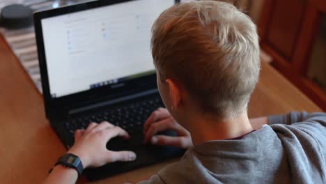 focused young adult reading research on a laptop