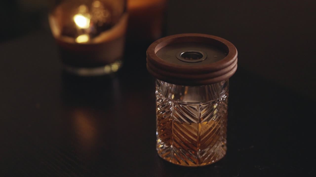 Affumicatura cocktail - Coperchio di legno affumicatore sopra il bicchiere da cocktail. - Primo piano.