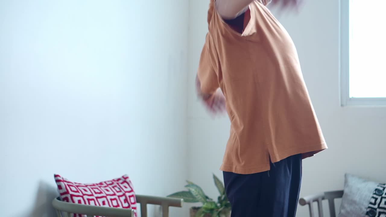 Elderly asian man stretching body after enjoying leisure time at home