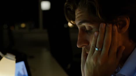 front view of tired young caucasian male executive working on computer at desk in modern office 4k