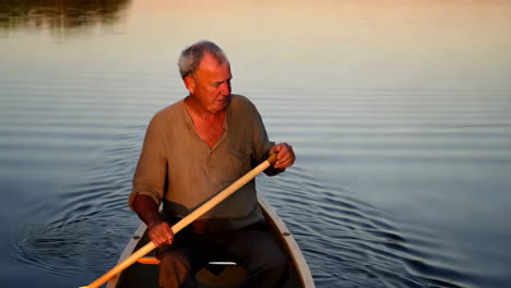 man kayaking on a peaceful lake at sunset