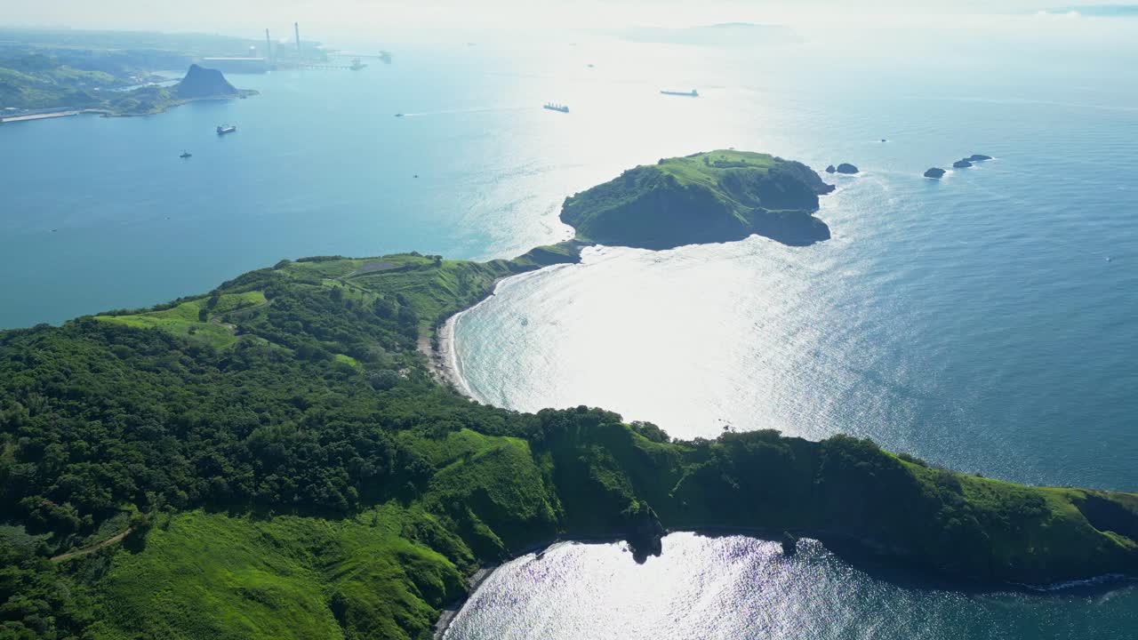 Slow‑rise aerial of Five Finger Cove in Mariveles, Bataan, lifting above rugged green cliffs and turquoise waters to reveal the sweeping coastline and serene ocean horizon
