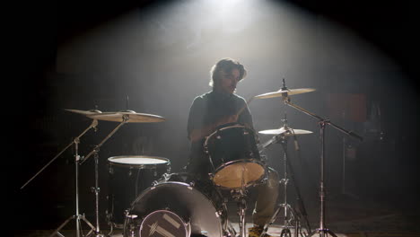 joven baterista tocando la batería en un estudio de música