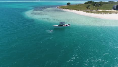 Drone-shot-BOAT-WITH-PEOPLE-BATH-AROUND-Caribbean-island-DOS-MOSQUISES-in-Los-Roques