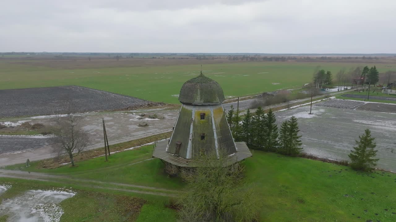 красивый вид с воздуха на старую деревянную ветряную мельницу посреди поля, ветряная мельница в пренклаву, пасмурный зимний день, съемка с беспилотника с широкой орбиты