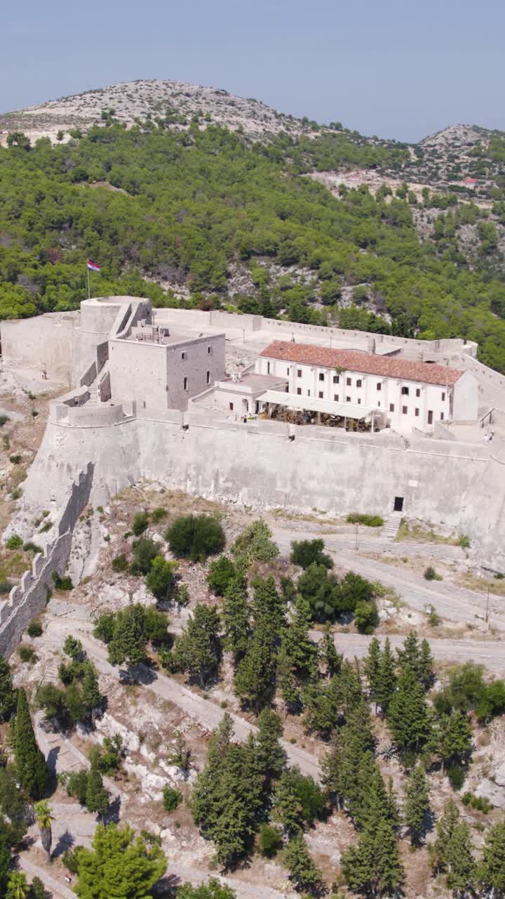 Aerial view of Fortica Fortress, also known as Spanjola, a historical landmark overlooking Hvar town in Croatia, showcasing its imposing structure and strategic location. Vertical video