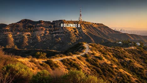 a captivating view of the iconic hollywood sign overlooking the landscape at sunset, surrounded by rolling hills and a beautiful gradation of light