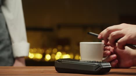 pagar con un primer plano de teléfono inteligente. comprar sin dinero en efectivo en un restaurante o cafetería. comprar café utilizando el concepto de pago sin contacto y sin contacto. tecnología nfc y terminal bancario.