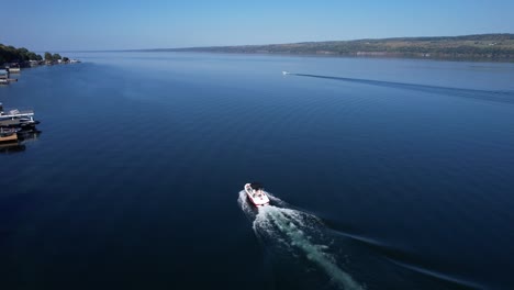 Vista-Aérea-Desde-Un-Dron-Siguiendo-Un-Barco-De-Esquí-En-El-Lago-Seneca-En-Finger-Lakes,-Nueva-York