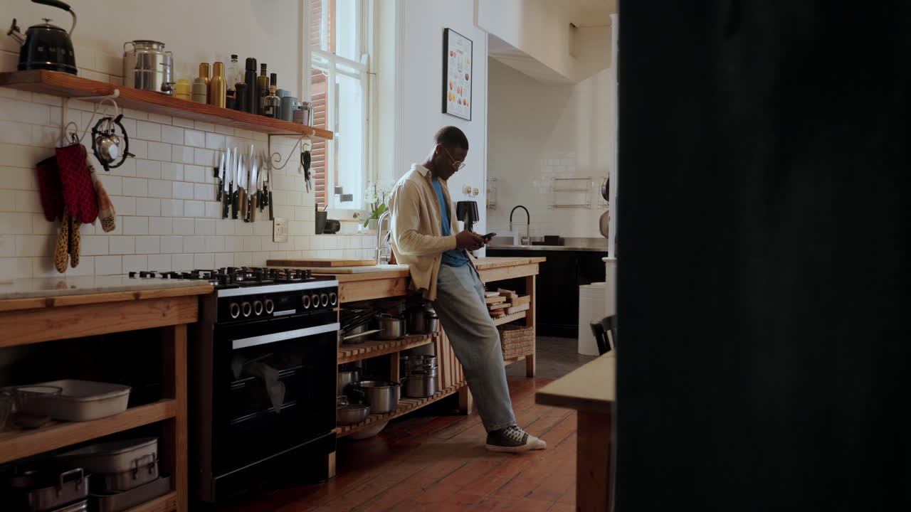 Un uomo che usa uno smartphone in una cucina moderna